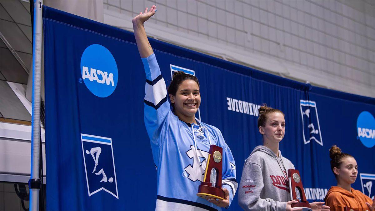 Aranza Vazquez Montaño holding a trophy and waving