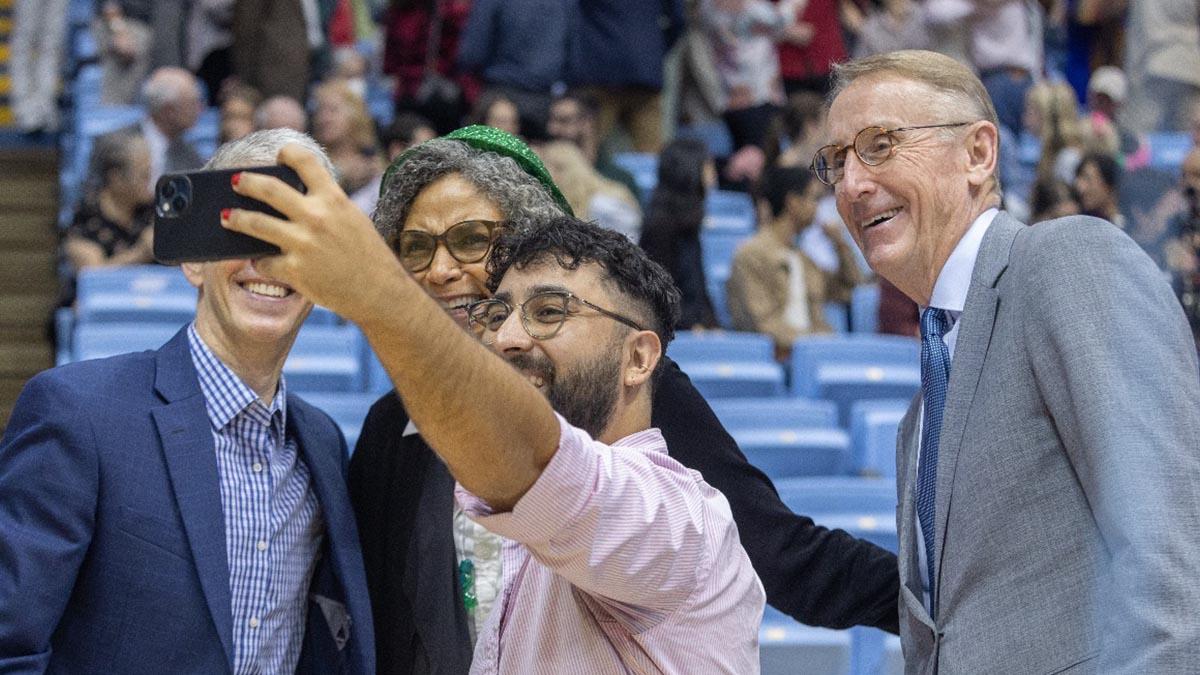 Person taking a selfie with three others