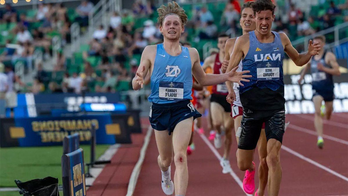 Parker Wolfe crossing the finish line on a track in the 5000m championship.