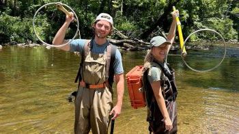 Tayton Alvis and Jenna Jordan holding backpack shockers during fish sampling at the Cullasaja River.