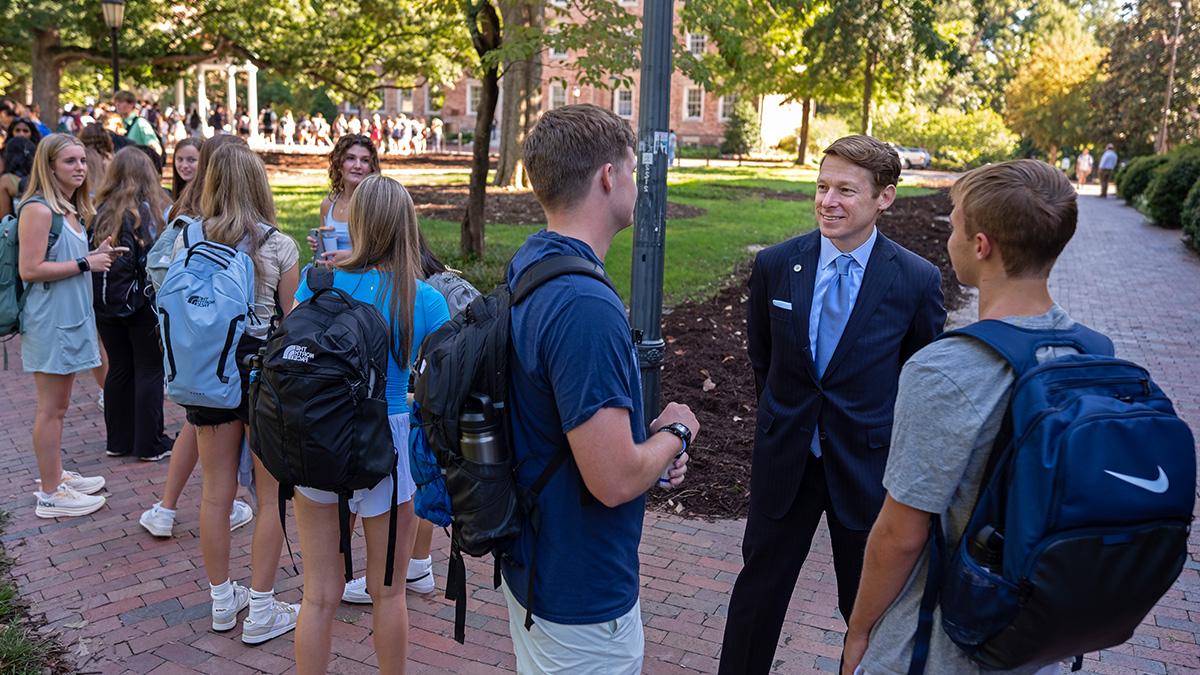 李H. Roberts meets with students near the Old Well